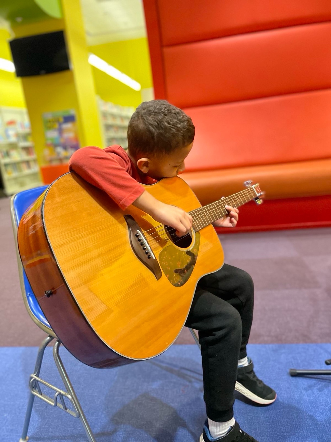 Leonardo playing guitar in a chair